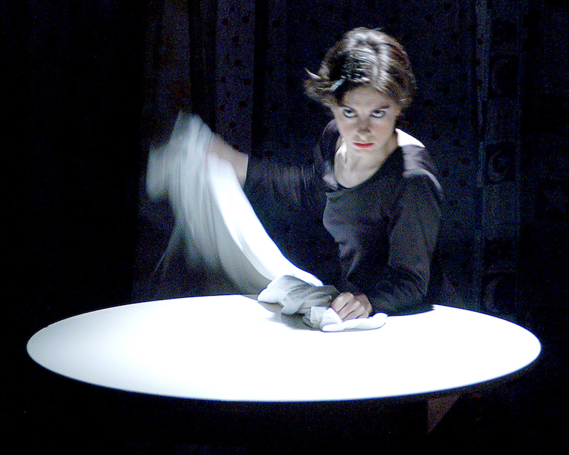 Anabella Lenzu stands around a white table holding a white scarf.